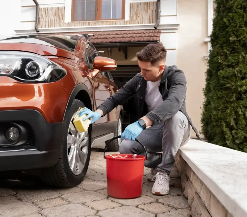 Lavage auto à domicile Les Contamines-Montjoie : professionnel intervenant sur un véhicule